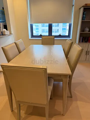 Light wood dining table with 6 upholstered chairs and library