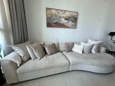 Light beige curved 4-seater sofa with chaise, good condition