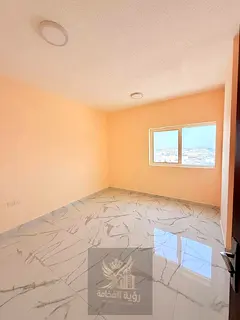 A room and a lounge for the first resident in Al Bu Tinah, with modern finishing and a vital locatio