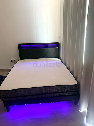 Queen bed frame with mattress and LED lighting