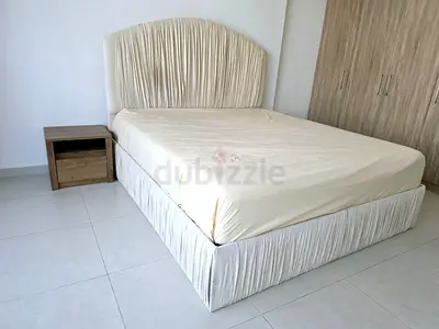 King bed with upholstered headboard and base (cream) with bedside table