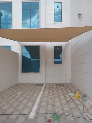 Covered outdoor patio with tiled flooring and sunshade
