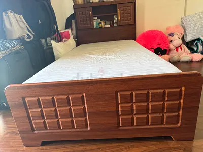 Single bed along with a mattress and comod