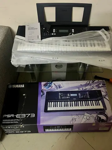 Yamaha PSR-E373 keyboard with original box — good working condition with glass stand with rollers
