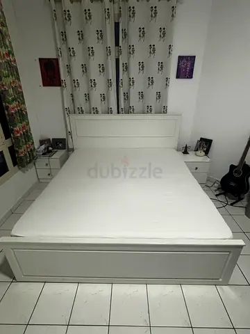 White engineered wooden sturdy double bed frame with mattress and bedside tables . With storage .