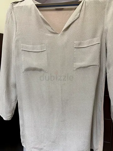 Light beige V-neck long-sleeve tunic with front pockets, size not specified
