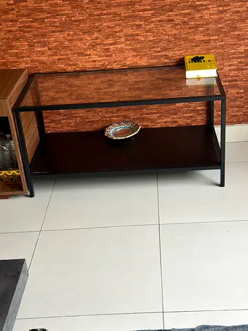 Simple rectangular glass-top coffee table with lower shelf