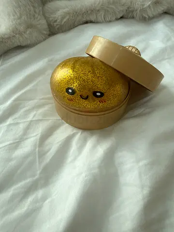 Small glitter orbeez dumpling in round beige container (used)