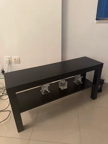 Black rectangular TV table with lower shelf. One corner is slightly damaged but not very noticeable