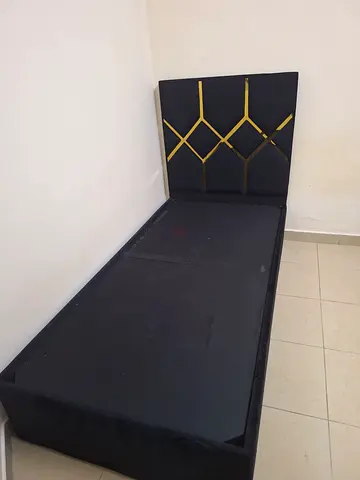 Single black upholstered bed frame with geometric headboard