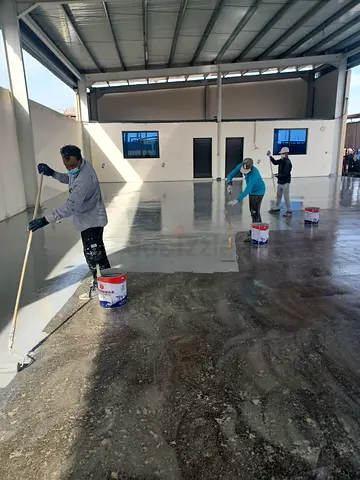 Industrial epoxy floor coating job - partially completed warehouse floor