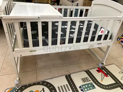 White Wooden Baby Crib with Adjustable Height and Wheels Teknum 7 in 1 usage