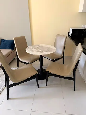 Compact marble-top dining table with four beige chairs - good condition