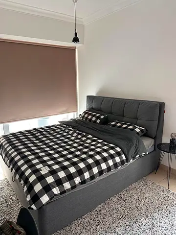 Grey upholstered double bed with storage and headboard