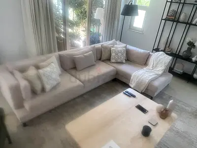 Light beige L-shaped sectional sofa with cushions