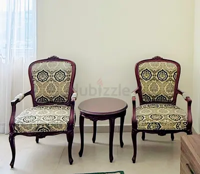 Pair of vintage carved wood armchairs with side table