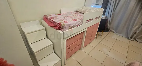 White and pink wooden kids bunk bed with table, drawers , steps with drawers and cupboard