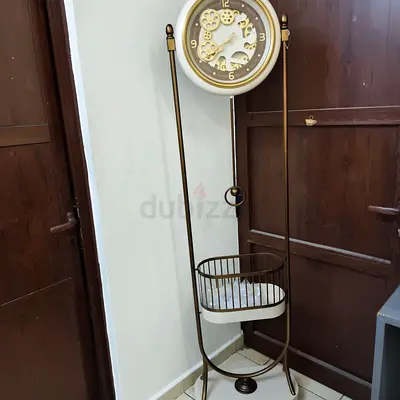 Tall decorative floor clock with attached storage basket
