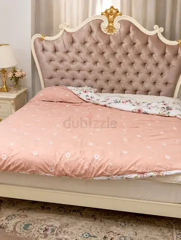 Antique-style tufted queen bed with ornate headboard