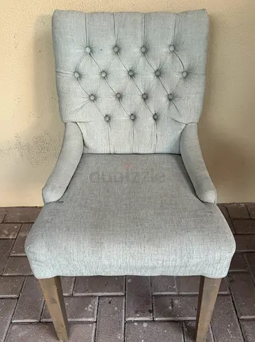 Light grey upholstered dining chair with wooden legs (used)