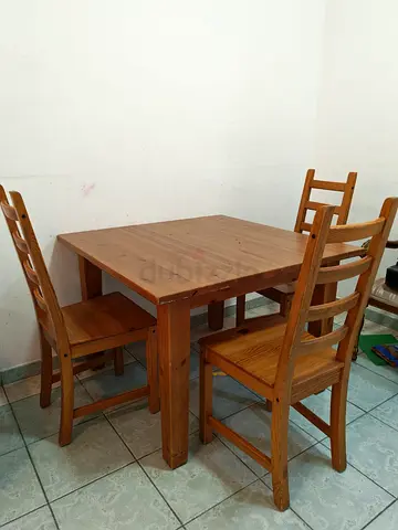 Square wooden dining table with three matching chairs