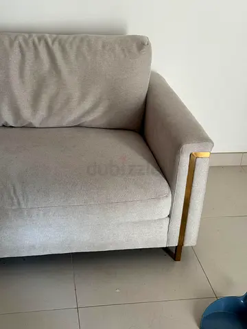 Light grey 2-seater sofa with gold metal accents