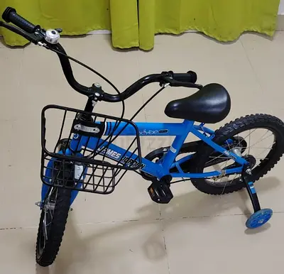 Blue kids bicycle with training wheels and front basket - good condition.
