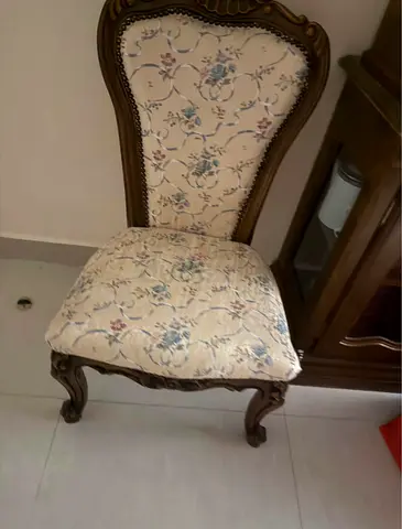 Antique-style carved wooden dining chair with floral upholstery