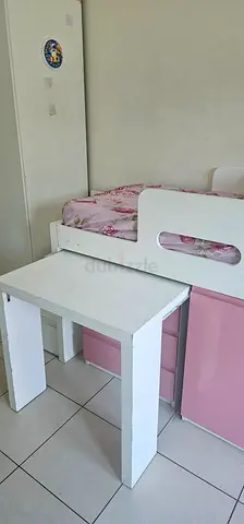 White and pink wooden kids bunk bed with table, drawers , steps with drawers and cupboard