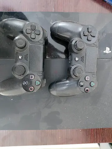 PlayStation 4 console with two DualShock 4 controllers - used