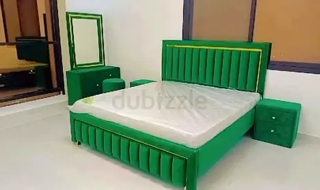 Green upholstered king bed with matching bedside tables and dresser