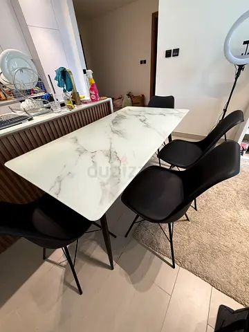Modern marble-top dining table with 4 black chairs