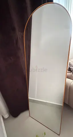 Full-length freestanding arched mirror with gold frame and tripod stand