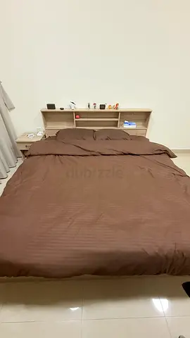 Wooden bed frame with built-in headboard storage and bedside drawers