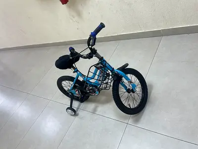 Blue kids bicycle with training wheels and front basket - good condition