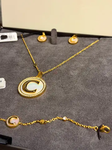 Gold-tone mother-of-pearl pendant necklace with matching earrings and bracelet set