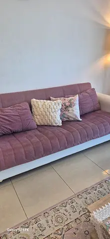 Two Three-seater sofa beds and two armchairs in mauve with cushions - good condition