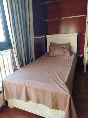 Single white wooden bed with headboard and mattress