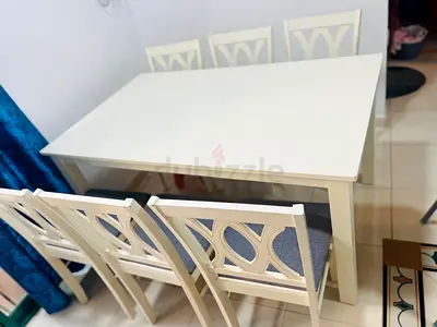 White wooden dining table with 6 matching chairs