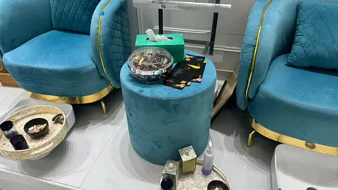 Pair of teal velvet accent chairs with matching ottoman