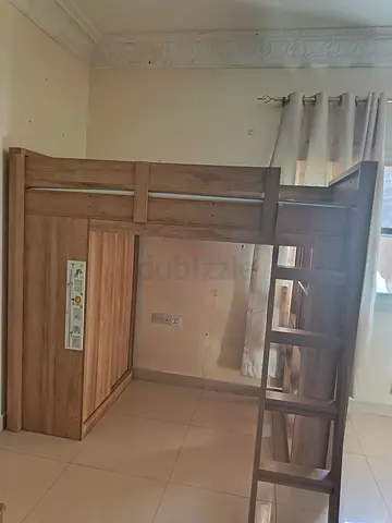 Wooden loft bed with built-in wardrobe and ladder