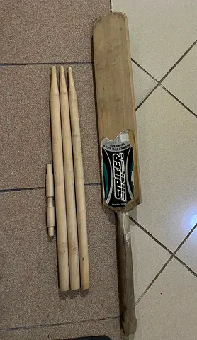 Used cricket bat with wooden stumps and bails