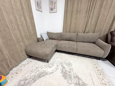 L-shaped grey fabric sectional sofa - very good condition. 1 year old. No pets.  Located Al Manara