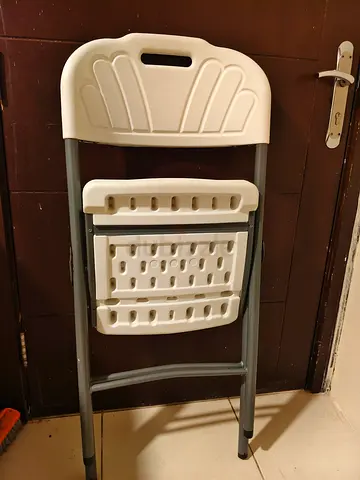 White plastic folding chair with metal frame - used