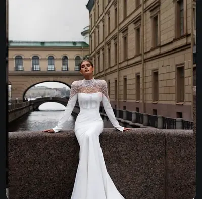 Elegant long-sleeve white bridal gown with illusion beaded neckline