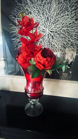 Decorative red glass vase with artificial red flowers