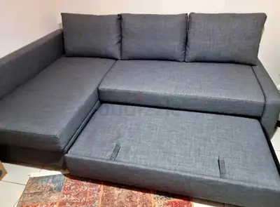 L-shaped grey fabric sofa with pull-out bed - good condition