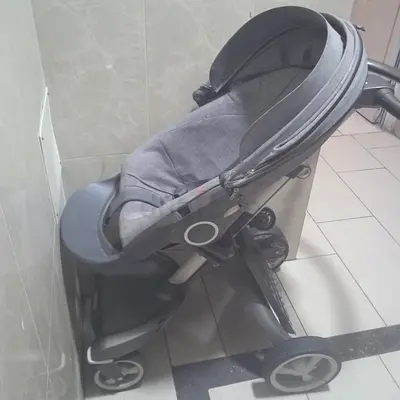 Lightly used grey Stokke stroller with reclining seat and sun canopy