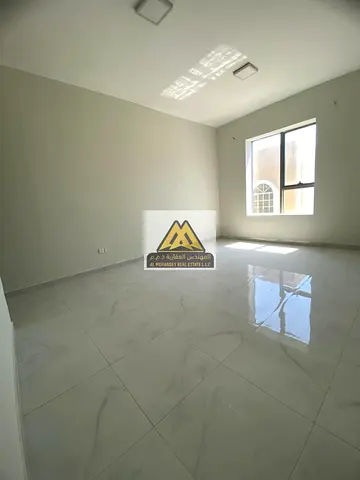 Premium real estate listing for an exceptionally spacious 1-bedroom apartment (1BHK) available for annual lease in Al Rawda 3, Ajman. Positioned dire