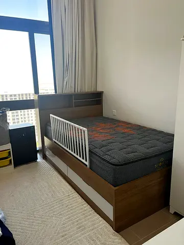 Single toddler bed with mattress and safety rail and storage drawers